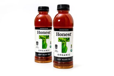 6 Mart 2023. Spartanburg, SC USA. Temiz arka planda iki şişe şekersiz organik siyah çay. Yeşil aksanlar çayların taze malzemelerini vurguluyor..