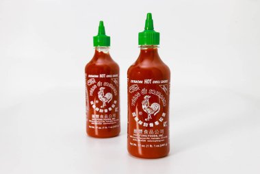 4 Şubat 2023. Spartanburg, SC USA. İki şişe Sriracha baharatlı biber sosu. Beyaz yüzeyde yeşil kapaklı..