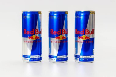 23 Şubat 2023. Spartanburg, SC USA. Temiz yüzeyde düzgün düzenlenmiş üç kutu Red Bull popüler enerji içeceği. Tasarım cesur markalaşma, enerji ve canlılığı vurguluyor.