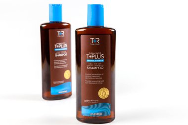 July 6, 2023. Spartanburg, SC USA. True plus real therapeutic shampoo bottles displayed on white surface, showcasing their sleek design and blue caps. clipart