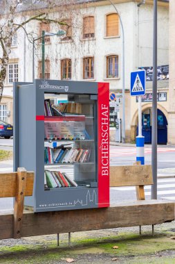 Echternach, Luxembourg - Januari 1, 2023: Cityscape of Echternach with little free public library cabinet promoting reading in oldest town in Luxembourg. Near Mullerthal.