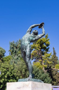 Athens, Greece - September 25, 2021: Bronze discobolus sculpture atlete in front of he Panathenaic Stadium or Kallimarmaro in Athens in Greece