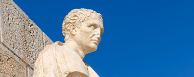 Athens, Greece: September 24, 2021: Antique statue of Menander, the ancient Greek playwright and comedian below the Acropolis site on a sunny evening in Athens in Greece