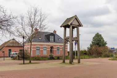 Onnen, Hollanda - 20 Mart 2023: Ahşap çan kulesi ve Hollanda 'daki Onnen belediyesi Groningen' deki geleneksel ev