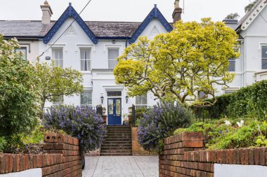 İrlanda 'nın Cork Munster bölgesindeki Lee nehri boyunca tuğla duvarlarla çevrili süslü ön bahçe.