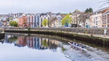 Mantar, İrlanda - 16 Nisan 2023: İrlanda 'nın Munster eyaletinin merkezinde bulunan Lee Nehri' nde kürek çeken şehir manzarası