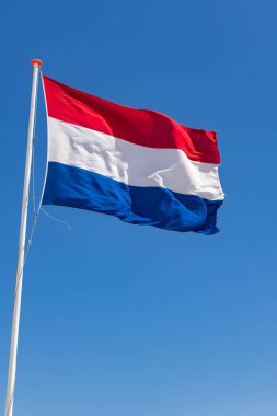 Hollanda 'da mavi bir gökyüzünün önünde Hollanda bayrağı sallıyordu.