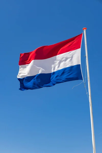 Κυματίζει Την Ολλανδική Σημαία Μπροστά Από Έναν Γαλάζιο Ουρανό Στην — Φωτογραφία Αρχείου