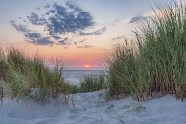 Hollanda 'nın Terschelling Friesland eyaletinin Wadden Adası plajında gün batımında kum tepeleri manzarası