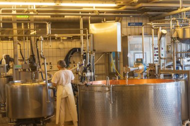 Affoltern, İsviçre - 17 Mayıs 2023: İsviçre Emmental Canton Bern 'de Affoltern' de peynir fabrikasında çalışan kadın operatör