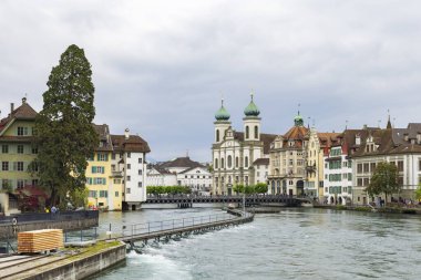 Lucerrne, İsviçre - 18 Mayıs 2023: İsviçre 'nin tarihi merkezi Lucerne' de Reuss nehri ve Cizvit Kilisesi ile sokak manzarası