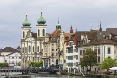 Lucerrne, İsviçre - 18 Mayıs 2023: İsviçre 'nin tarihi merkezi Lucerne' de Reuss nehri ve Cizvit Kilisesi ile sokak manzarası