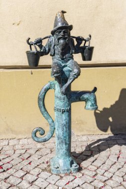 Wroclaw, Polonya - 20 Temmuz 2023: Wroclaw tarihinin başkenti Silezya ve Polonya 'nın cüce şehrinde su pompasında iki kova su bulunan cüce heykeli.