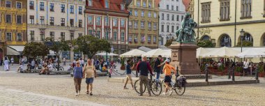 Wroclaw, Polonya - 20 Temmuz 2023: Pazar meydanından ve Wroclaw tarihi başkenti Polonya 'daki belediye binasından geçen turist