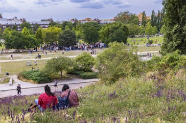 Berlin, Almanya - 23 Temmuz 2023: Almanya 'nın Berlins Prenzlauer Berg ilçesinde Mauerpark' taki tepenin manzarasının keyfini çıkaran insanlar.