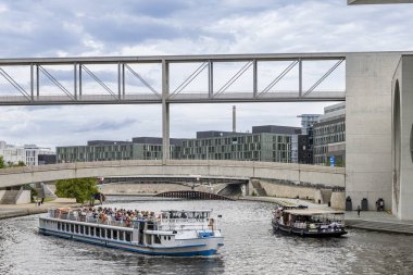Berlin, Almanya - 24 Temmuz 2023: Spree Nehri 'nde turist botu Almanya' da Berlin 'de modern mimari boyunca yelken açıyor.