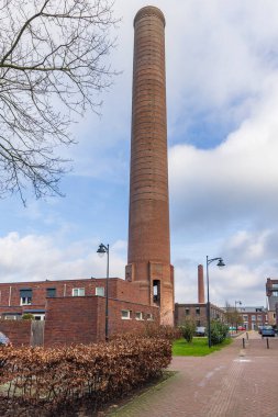 Ede, Hollanda - 1 Mart 2024: Hollanda 'nın Gelderland eyaleti Ede kentindeki ENKA fabrikasının eski kulelerini çevreleyen modern yeni inşa edilmiş evler.