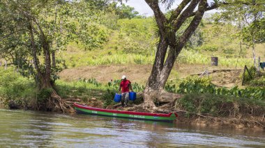 El Castillo, Nikaragua - 11 Mart 2024: Nikaragua ve Kosta Rika sınırında Rio San Juan Biyosfer rezervi boyunca varil taşıyan yerel bir adam