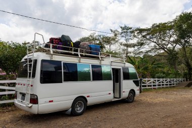 Çatıda bavulları olan küçük beyaz turist otobüsü Latin Amerika 'da Nikaragua' da seyahat ediyor.