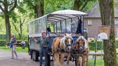 Orvelte, Hollanda - 9 Temmuz 2024: Hollanda Drenthe Hollanda 'da Orvelte Picuresque adlı küçük bir kasabada Haflinger atlarıyla kapalı turist vagonu.