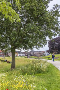 Coevorden, The Netherlands - July 12, 2024: Woman walking in the main park and garden near the city hall of Coevorden in Drenthe The Netherlands clipart