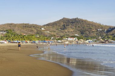 San Juan del Sur, Nikaragua - 23 Mart 2024: İnsanlar Nikaragua 'nın güneybatısındaki Rivas bölgesinde Pasifik Okyanusu kıyısındaki San Juan del Sur sahil kasabasının tadını çıkarıyorlar..