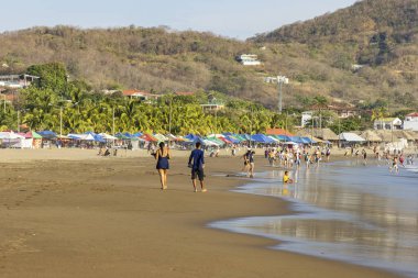San Juan del Sur, Nikaragua - 23 Mart 2024: İnsanlar Nikaragua 'nın güneybatısındaki Rivas bölgesinde Pasifik Okyanusu kıyısındaki San Juan del Sur sahil kasabasının tadını çıkarıyorlar..