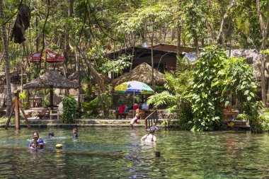 Ometepe, Nikaragua - 21 Mart 2024: İnsanlar Nikaragua 'nın güneybatısındaki Cocibolca Gölü' ndeki Ometepe Adası 'nda Doğa Koruma Alanı' nda ve Ojo de Agua havuzunda eğleniyorlar. Doğal havuzda yüzmek.