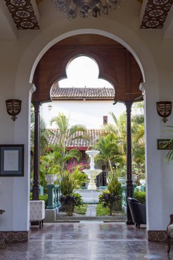 Granada, Nikaragua - 20 Mart 2024: Nikaragua Orta Amerika 'daki Nikaragua Gölü kıyısındaki Granada' da bahçe ve çeşme manzaralı otel koloni binasına giriş