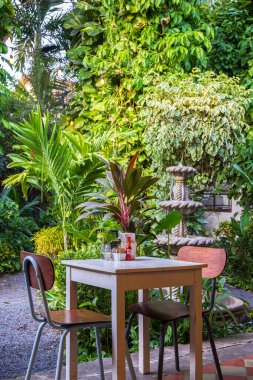 Granada, Nikaragua - 20 Mart 2024: Nikaragua Orta Amerika 'daki Nikaragua Gölü kıyısındaki Granada' da bahçe restoranında yeşil sandalyeli masa