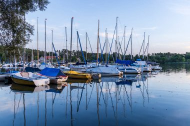 Almanya 'nın Bavyera kentindeki Nuremberg yakınlarında mavi saatte Rothsee Gölü' nde yelkenli gemilerle küçük bir liman.