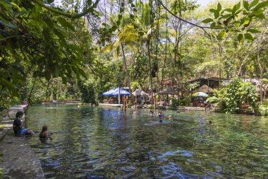 Ometepe, Nikaragua - 21 Mart 2024: İnsanlar Nikaragua 'nın güneybatısındaki Cocibolca Gölü' ndeki Ometepe Adası 'nda Doğa Koruma Alanı' nda ve Ojo de Agua havuzunda eğleniyorlar. Doğal havuzda yüzmek.