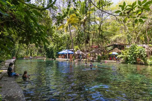 Ometepe, Nikaragua - 21 Mart 2024: İnsanlar Nikaragua 'nın güneybatısındaki Cocibolca Gölü' ndeki Ometepe Adası 'nda Doğa Koruma Alanı' nda ve Ojo de Agua havuzunda eğleniyorlar. Doğal havuzda yüzmek.