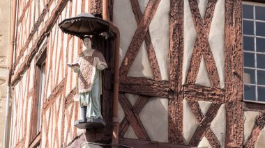 Chalon-sur-Saone, Fransa - 30 Nisan 2024: Fransa 'nın Bourgogne bölgesindeki Chalon-sur-Saone bölgesindeki Saint Vincent Meydanı' nda yarı keresteli bir binada dini heykel