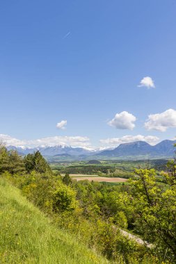 Landscape with scenic view of surroundings picturesque village Saint Maurice en Trieves in Auvergne Rhone region in France with Alpes mountains in the background clipart