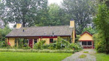 Gees, Hollanda - 21 Haziran 2024: Gees Hollanda 'da güzel bir çiçek bahçesi ile çevrili çok renkli konforlu ev.