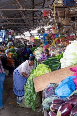 Arusha, Tanzanya - 16 Kasım 2024: Doğu Afrika 'nın Arusha kentindeki renkli yerel pazarda kadınlar mallarını satıyor