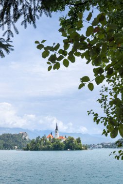 Slovenya 'nın Gorenjska bölgesindeki Bled şehrinin beyaz kilise ve Bled kalesi yüksek kayalıklarda bulunan görkemli Bled Adası manzarası