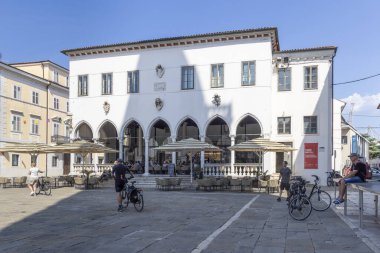 Koper, Slovenya - 30 Ağustos 2024: Slovenya 'daki Adriyatik Denizi kıyısındaki Istrian yarımadasındaki Tito Meydanı' ndaki Loggia Palace restoranı manzaralı Izola şehri
