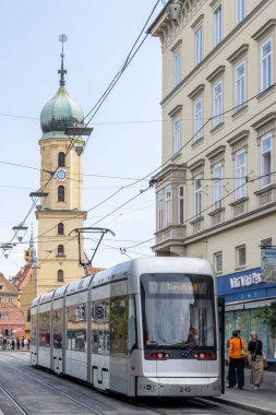 Graz, Avusturya - 6 Eylül 2024: Avusturya 'nın Stiermarken bölgesindeki Graz şehir merkezindeki Saat Kulesi ve metro otobüsünün manzarası