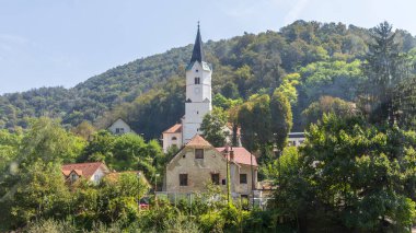 Slovenya 'da beyaz kilisesi ve kırmızı çatılı evleri olan tipik Sloven köyü Krsko