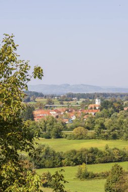 Slovenya 'da yaz aylarında kırmızı kiremitli ve kırmızı çatılı beyaz kiliseli tipik Sloven köyleri