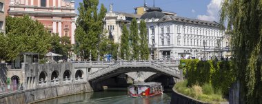 Ljubljana, Slovenya - 31 Ağustos 2024: Fransisken köprüsünün panoramik manzarası, Ljubljanica Nehri 'nde Ljubljana' nın başkenti Slovenya 'nın merkezinde tekne turu