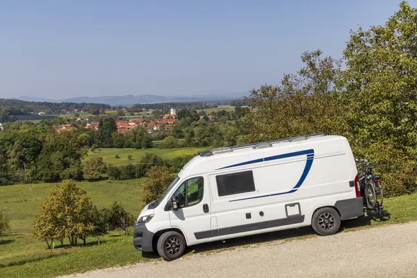 Arka planda güzel Slovenya tepe manzaralı beyaz karavan.