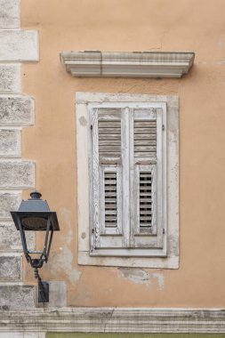 Slovenya 'daki Adriyatik denizi boyunca Piran Istrian yarımadasında panjurlu ve sokak lambalı şeftali renkli ev