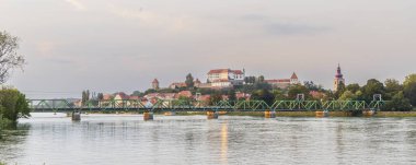 Günbatımında Slovenya 'nın Styria bölgesinde Ptuj yakınlarındaki Ptujsko Jezero Gölü ve Drava nehri boyunca uzanan Ptuj silueti