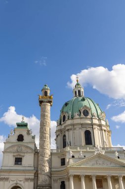 Viyana, Avusturya - 7 Eylül 2024: Viyana 'daki tarihi Karlskirche Kilisesi, kendine özgü bakır kubbesi, uzun sütun ve Avusturya' nın başkenti Viyana 'nın önünde heykel bulunan gölet