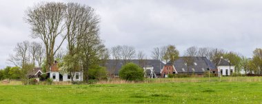 Leens, Hollanda 'daki Verhildersum' da tarımsal tarla ve meyve bahçesiyle çevrili panoramik bir çiftlik evi.