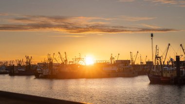 Hollanda limanı Lauwersoog 'un gün batımı manzarası Hollanda' nın Groningen kentindeki Waddensea boyunca uzanan balıkçı gemileriyle