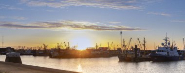 Hollanda limanı Lauwersoog 'un gün batımı manzarası Hollanda' nın Groningen kentindeki Waddensea boyunca uzanan balıkçı gemileriyle
